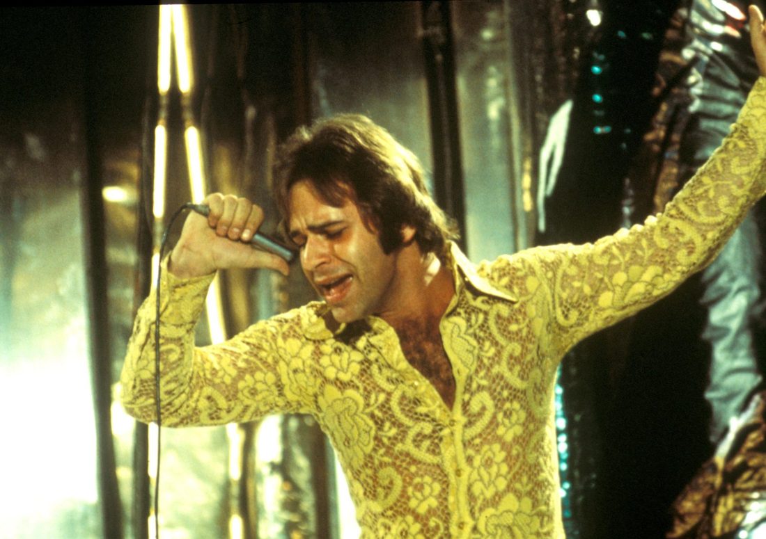 Lou Christie singing on stage in a yellow lace shirt